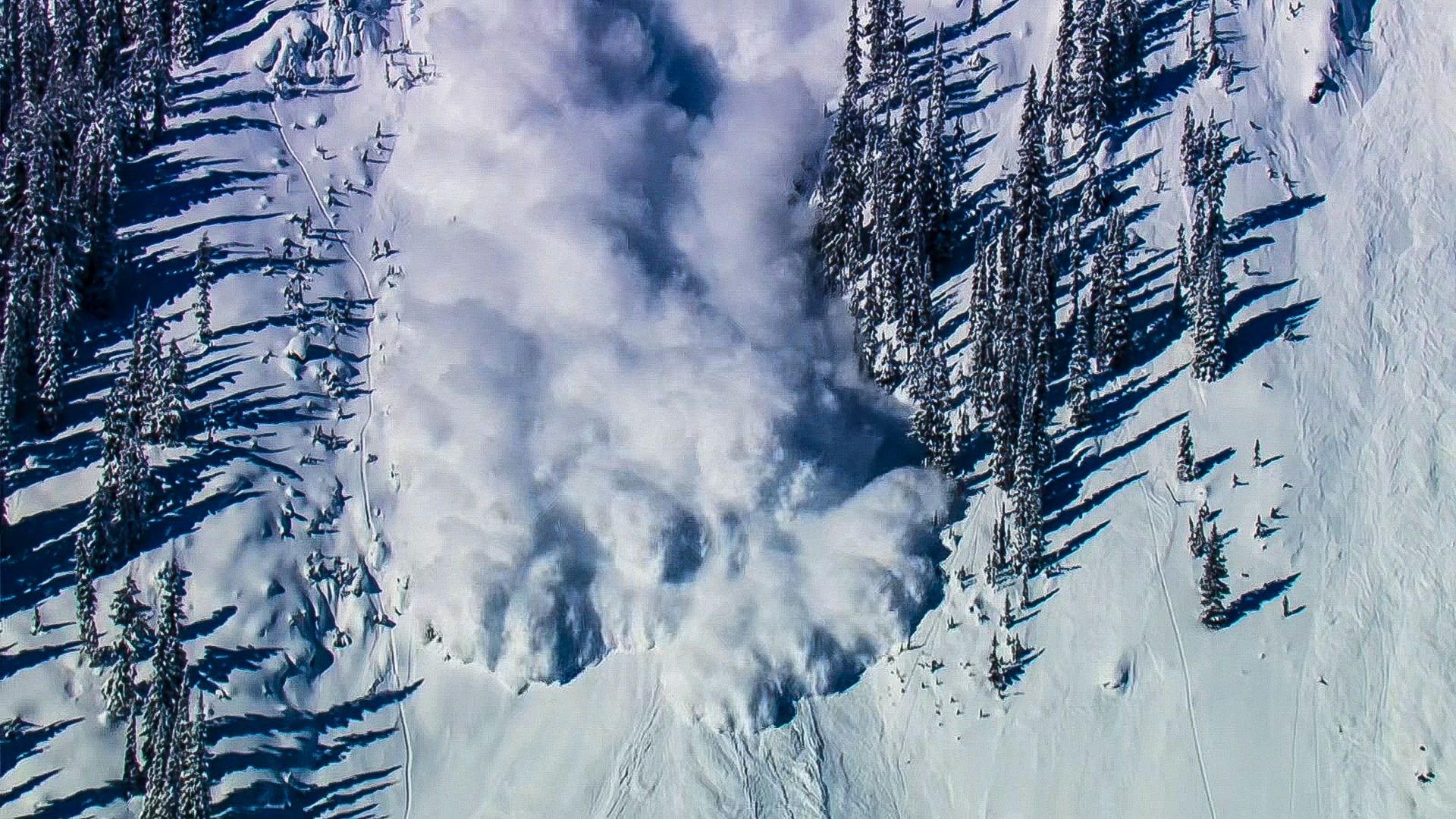 an avalanche of snow on a mountain seen from above