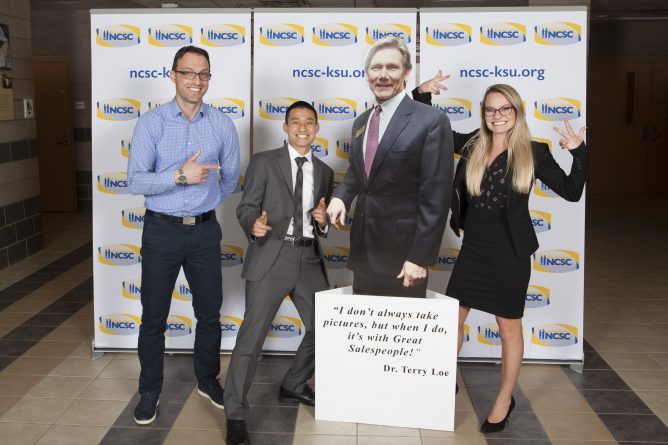 Professor Plamen Peev, Lary Zhang and Alicia jones posing with a cardboard cut out at the national collegiate sales competition
