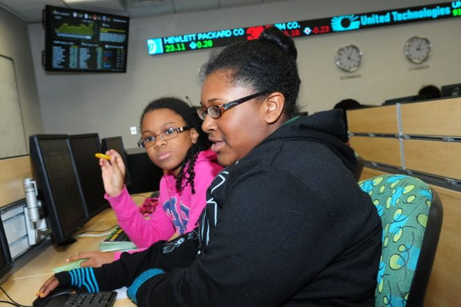 two young girls working at a bloomberg terminal in the finance lab