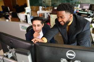 two student interns working at a computer at the world trade center institute