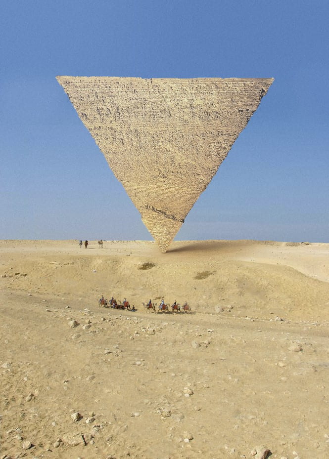 A pyramid balances on its point, upside down, in the desert with blue sky and small figures including a caravan of camels